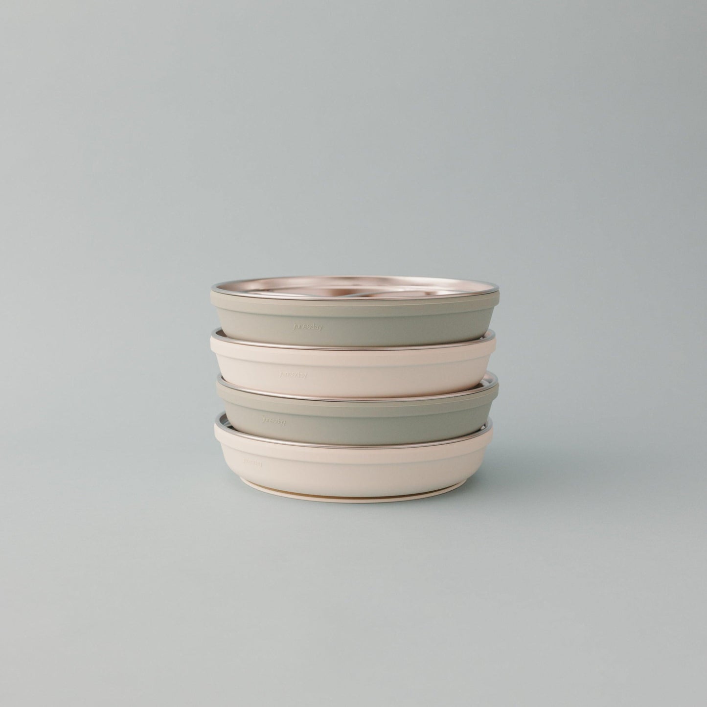 4 stainless steel suction plates stacked on top of one another alternating from oat and pistachio color.
