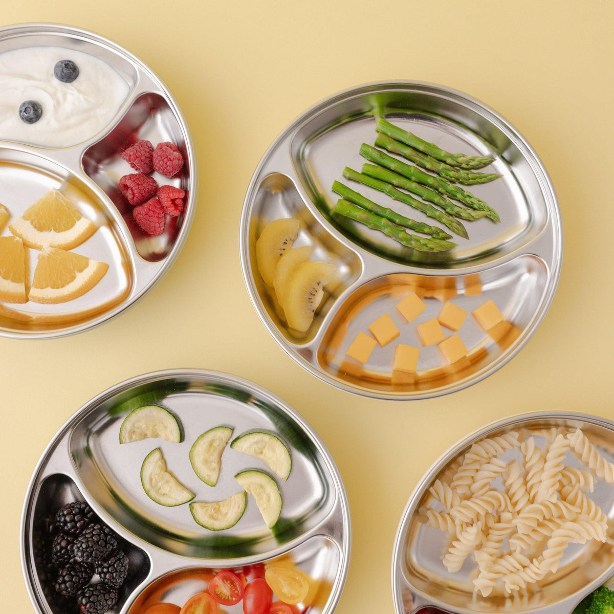 4 stainless steel plates with various healthy food in each compartment —nontoxic, microwave & dishwasher safe, designed in California, made in Korea.